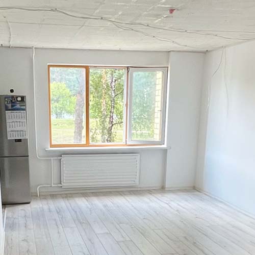 Buto vaizdas po remonto. Sudėtos naujas parketas, nudažytos baltos sienos.